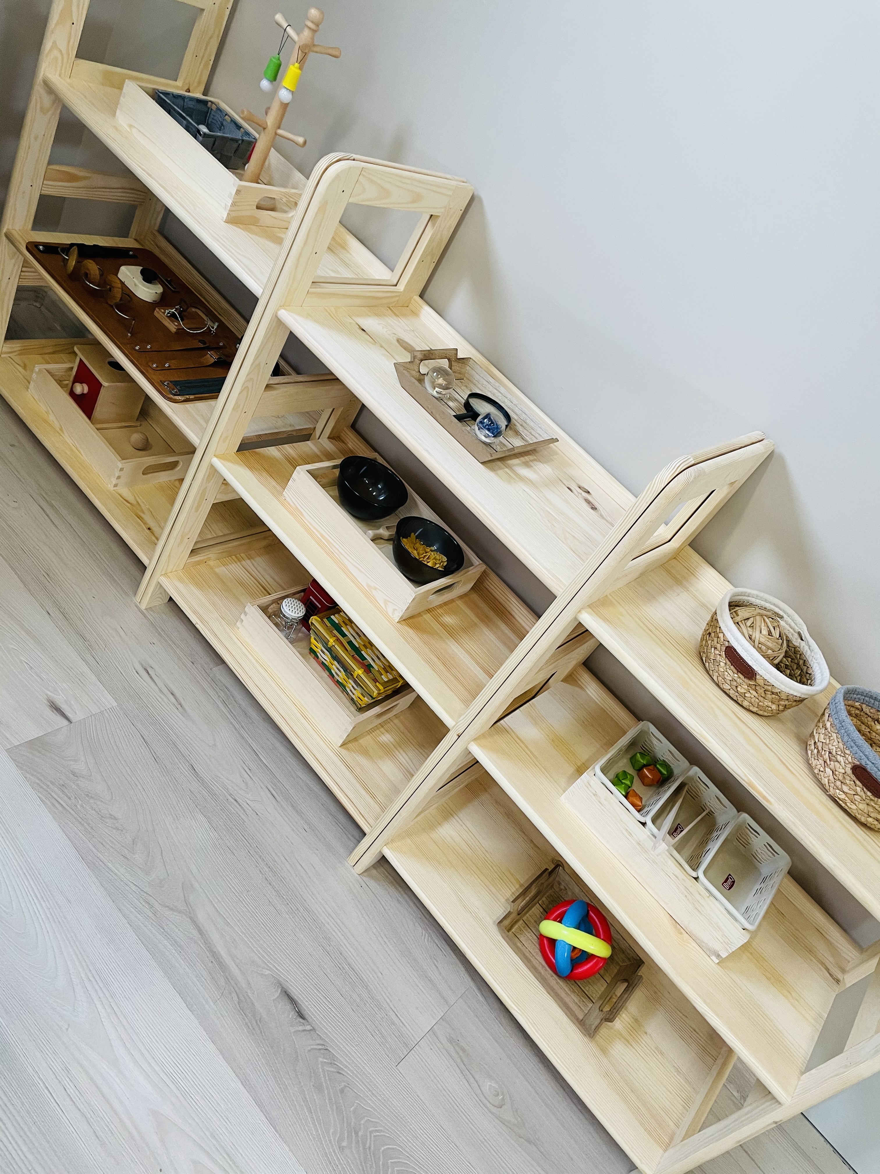Drewniane regały z pomocami Montessori w sali żłobka Jagódka w Legnicy
